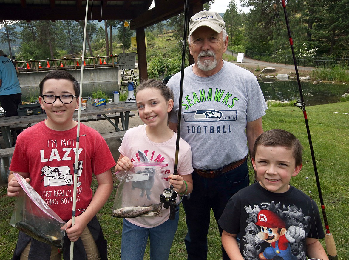 The Wright kids, from left, Thomas, Madeline and Nicholas, join grandfather Thomas Cherry after a day at the fishing derby at Falls Park in Post Falls.