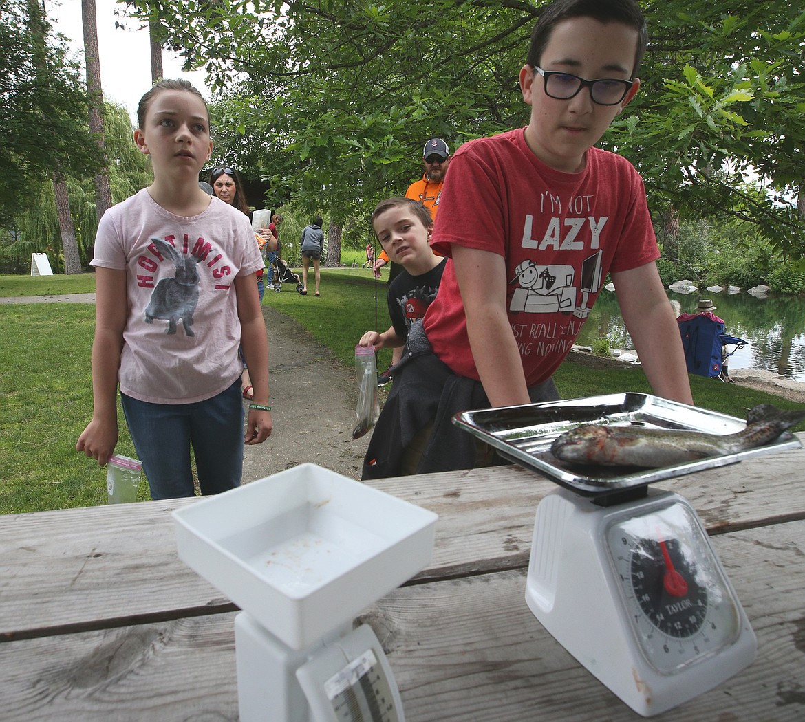 Thomas Wright weighs his fish while others wait their turn at the derby at Falls Park on Saturday.