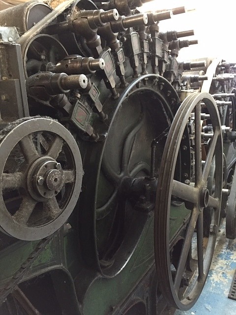 This close up of a 1910 Furber Davis tandem carder at Fibers First fiber processing mill in Post Falls aligns animal (hair/fleece) fiber during their process to becoming yarn. Fiber comes off the machine in a strip.