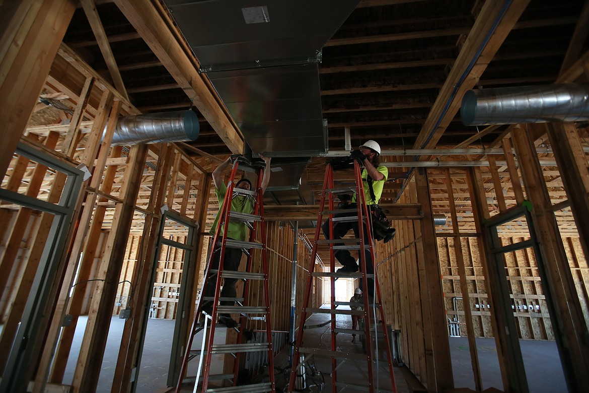 Project manager Vince Marmon, left, and installer Ryan Dolan of Trademark Mechanical Heating and Air Conditioning install ducts Tuesday in the new Hayden Canyon Charter, an expeditionary school of arts and sciences.