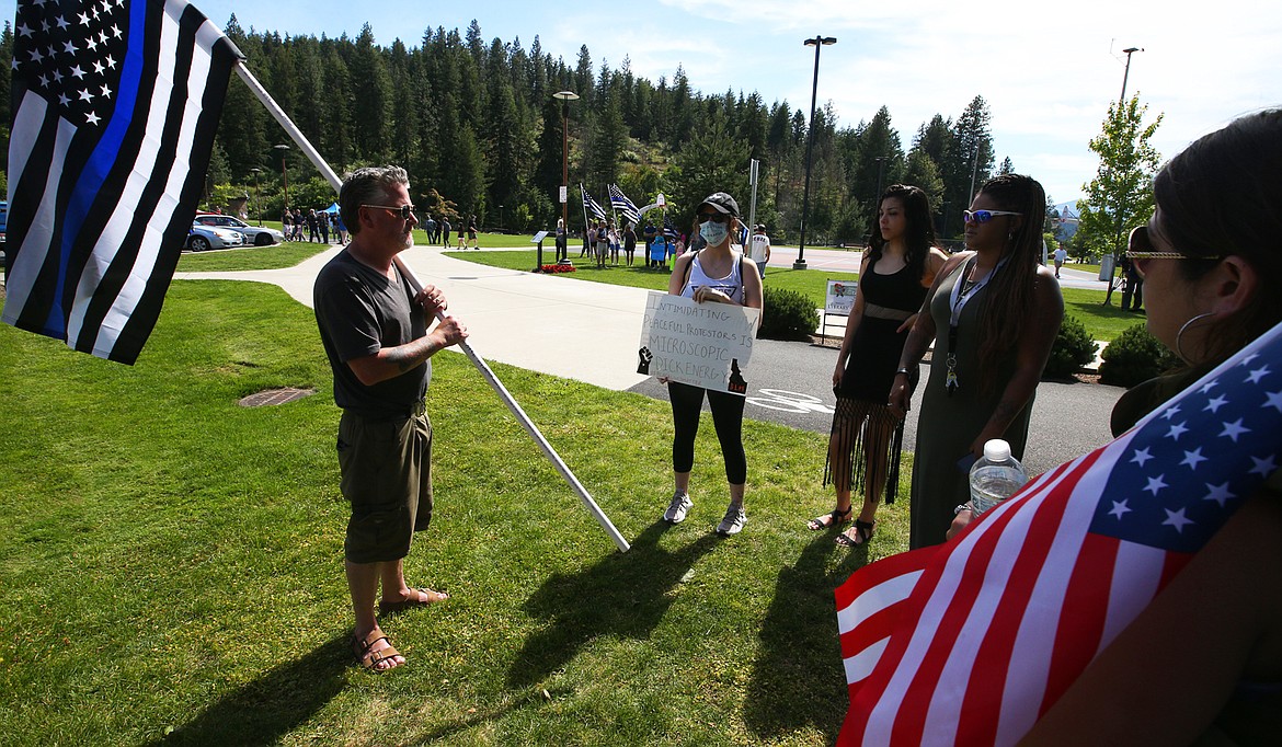 BILL BULEY/Press 
 Kelly Fee holds a flag as he talks with Black Lives Matter protesters on Tuesday at McEuen Park.