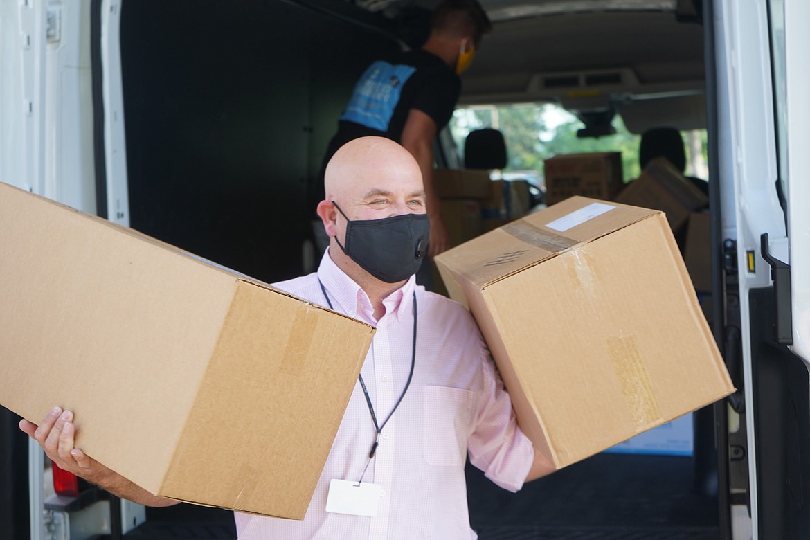 Heritage Health CEO Mike Baker carries boxes of personal protective equipment from the Idaho Primary Care Association.