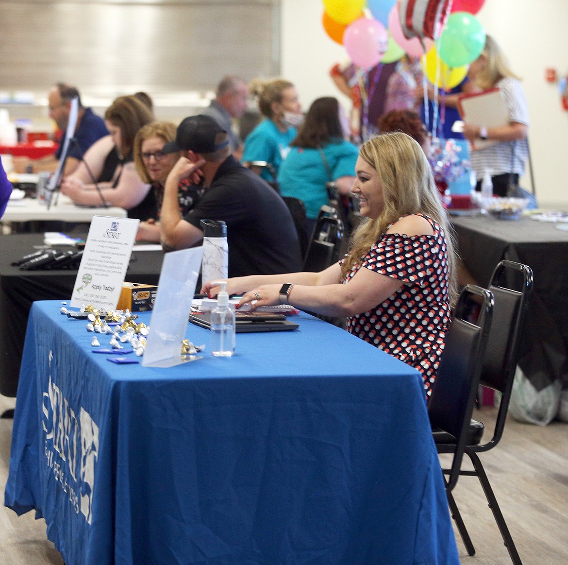 BILL BULEY/Press 
 Gina Gies, North Idaho recruitment coordinator for SL Start, mans a table at the job fair at the Lake City Center on Thursday.