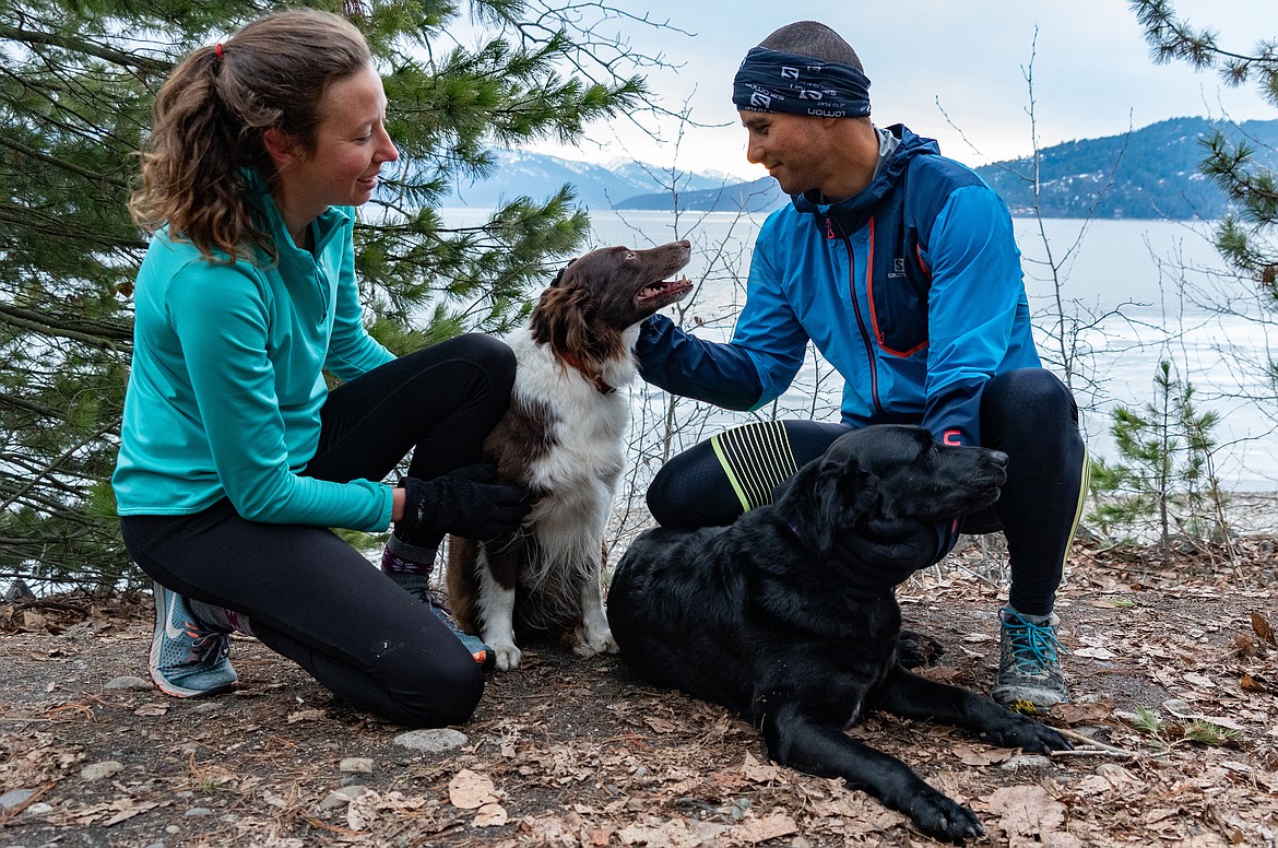 Runners give their four-legged friend some attention while running on the Pend d’Oreille Bay Trail recently.