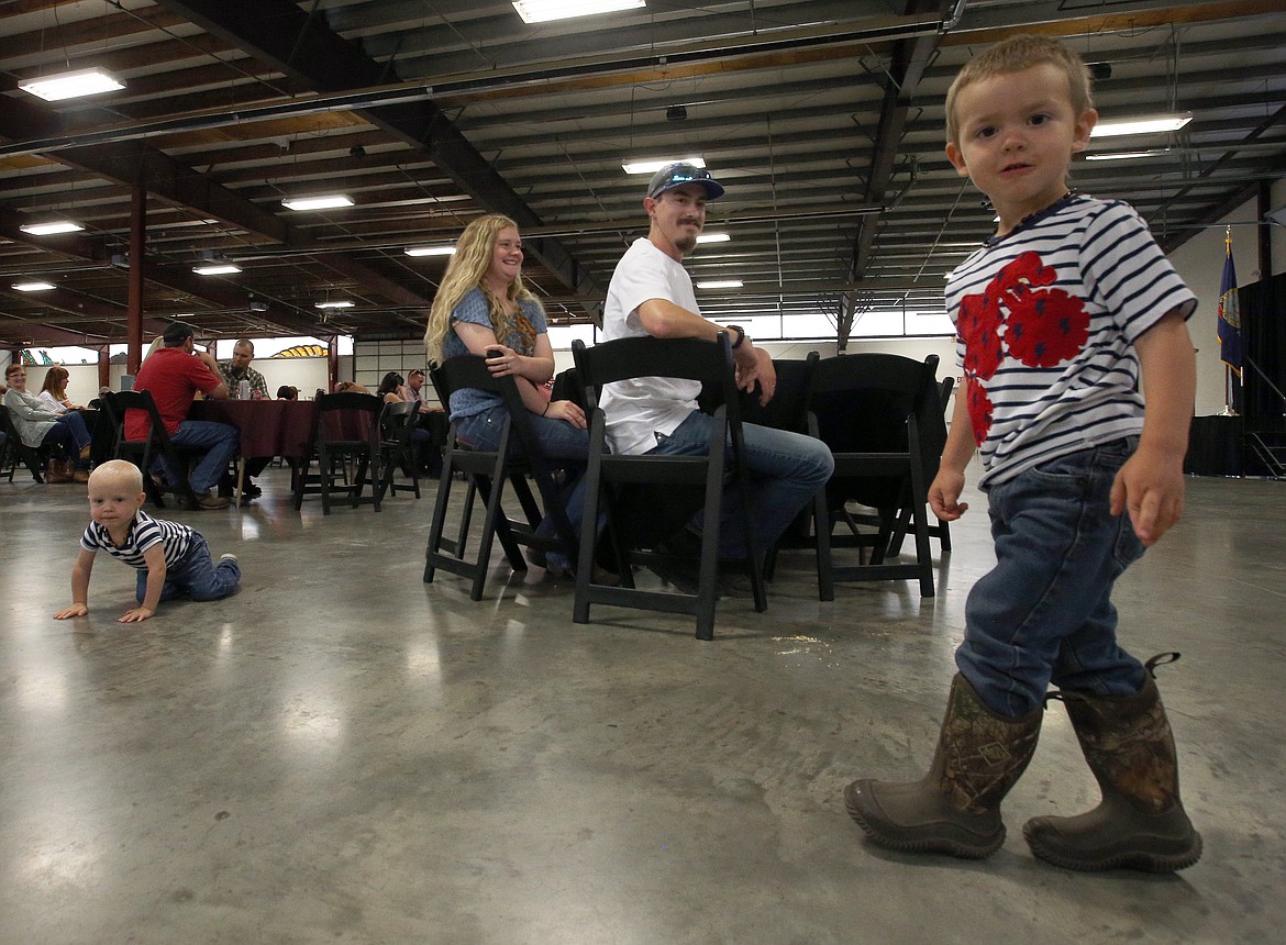 BILL BULEY/Press Conner and Renee Gunnoe watch their sons Lorenzo, left, and Ezra, play during the appreciation dinner Sunday night at the Kootenai County Fairgrounds.