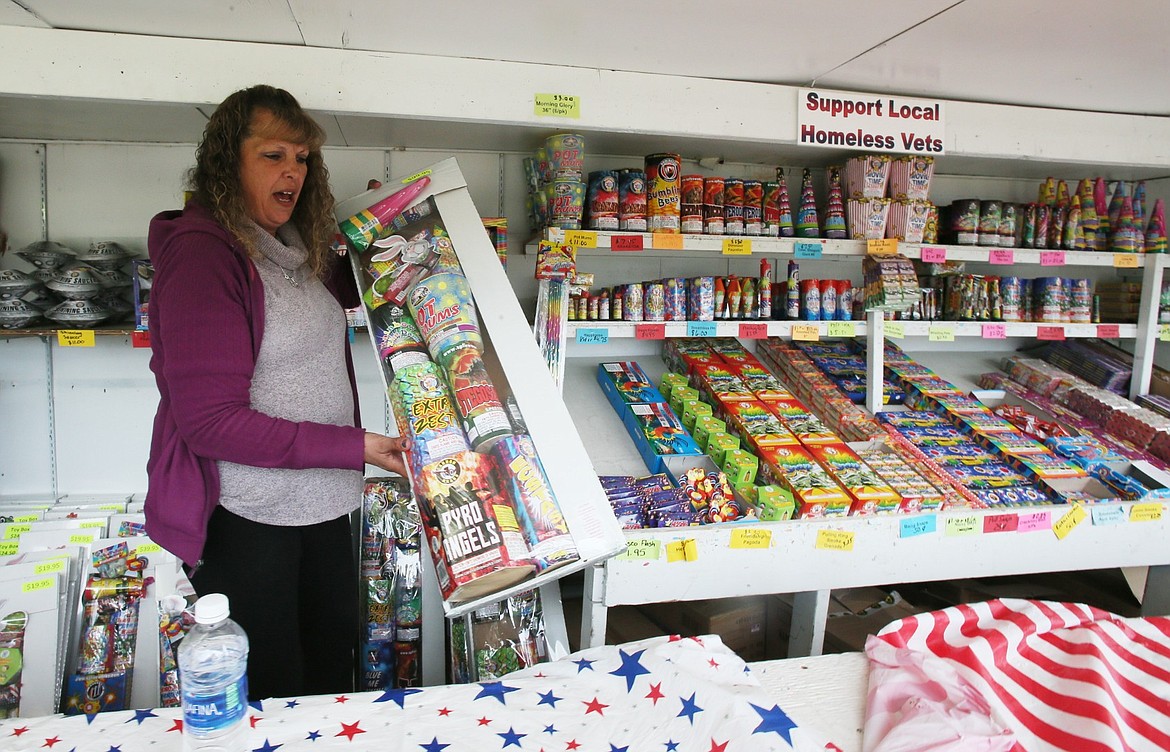 Big Boom Fireworks manager Cindy Richard shows off a popular package Wednesday in Post Falls. Fireworks stands are experiencing high volumes of sales ahead of the Fourth of July holiday as many people will be celebrating at home without big shows to attend. (DEVIN WEEKS/Press)