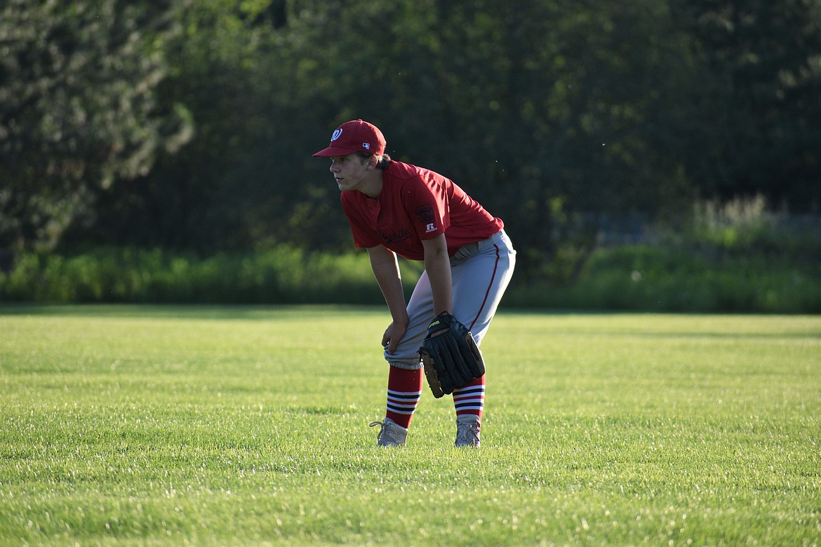 A Nationals player sits in the outfield and waits for the ball to come his way.