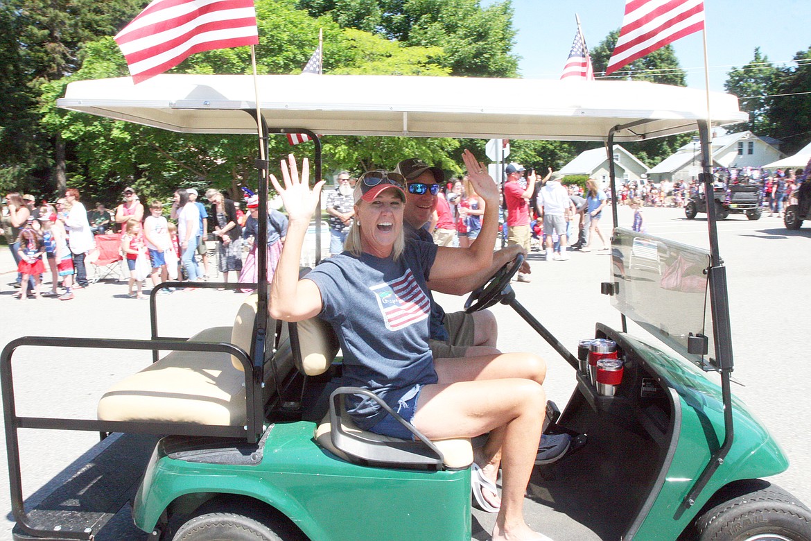 BILL BULEY/Press 
 Cheryl Hunter waves while husband Craig Hunter drives during the Fourth of July parade at Spirit Lake on Saturday.