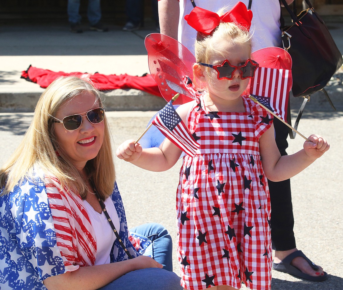 Lisa Clausen and daughter Claire Clausen of Coeur d’Alene watch Spirit Lake’s Fourth of July parade on Saturday.