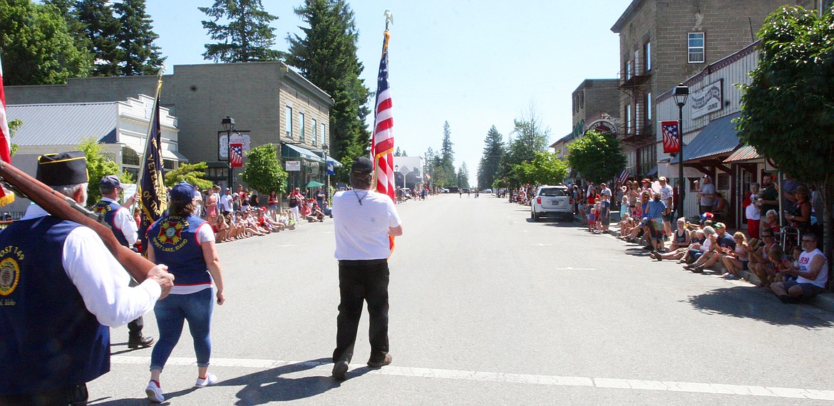 BILL BULEY/Press 
 David Owens carries the flag as he leads the Fourth of July parade up Maine Street on Saturday in Spirit Lake.