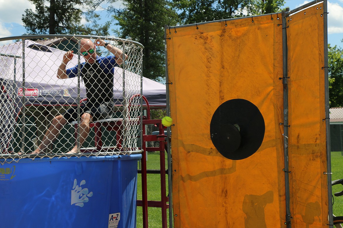 Sandpoint Councilman Andy Groat watches a ball head toward the target that could send him into the water as he mans the dunk tank booth at the Fourth of July activities at Travers Park on Saturday.