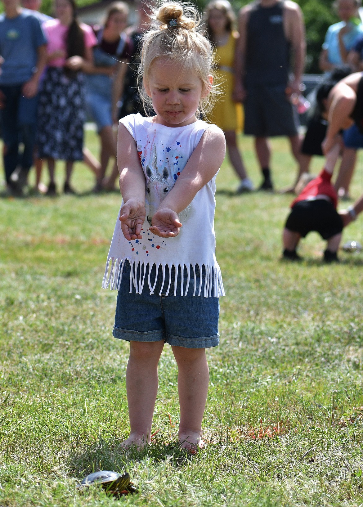 (Photo by DYLAN GREENE) 
 A youngster begs her turtle to move toward the finish line.
