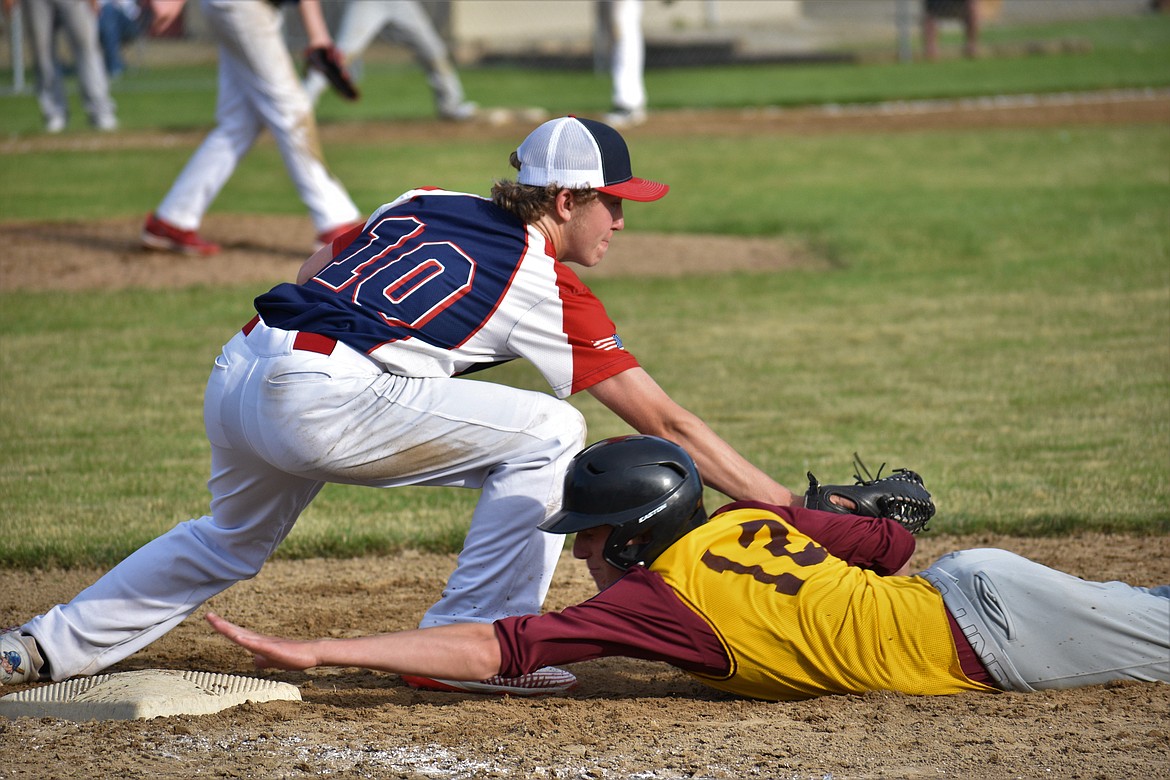 North Idaho Lakers 16U player Jack Zimmerman (left) attempts to tag a Silver Valley runner reaching for first base during the second game of a doubleheader last Wednesday at Pine Street Field.