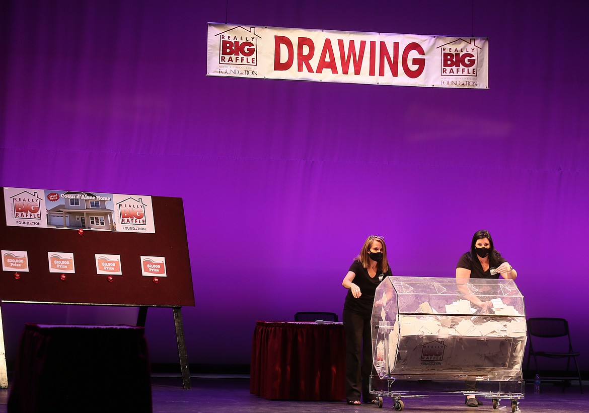 Darcy Ward, left, and Hannah Slusser of the North Idaho College Foundation spin the barrel of 5,500 raffle tickets Wednesday evening during the 27th annual Really BIG Raffle. It was held in the Schuler Performing Arts Center on the NIC campus as a closed event for safety amid the pandemic. (DEVIN WEEKS/Press)