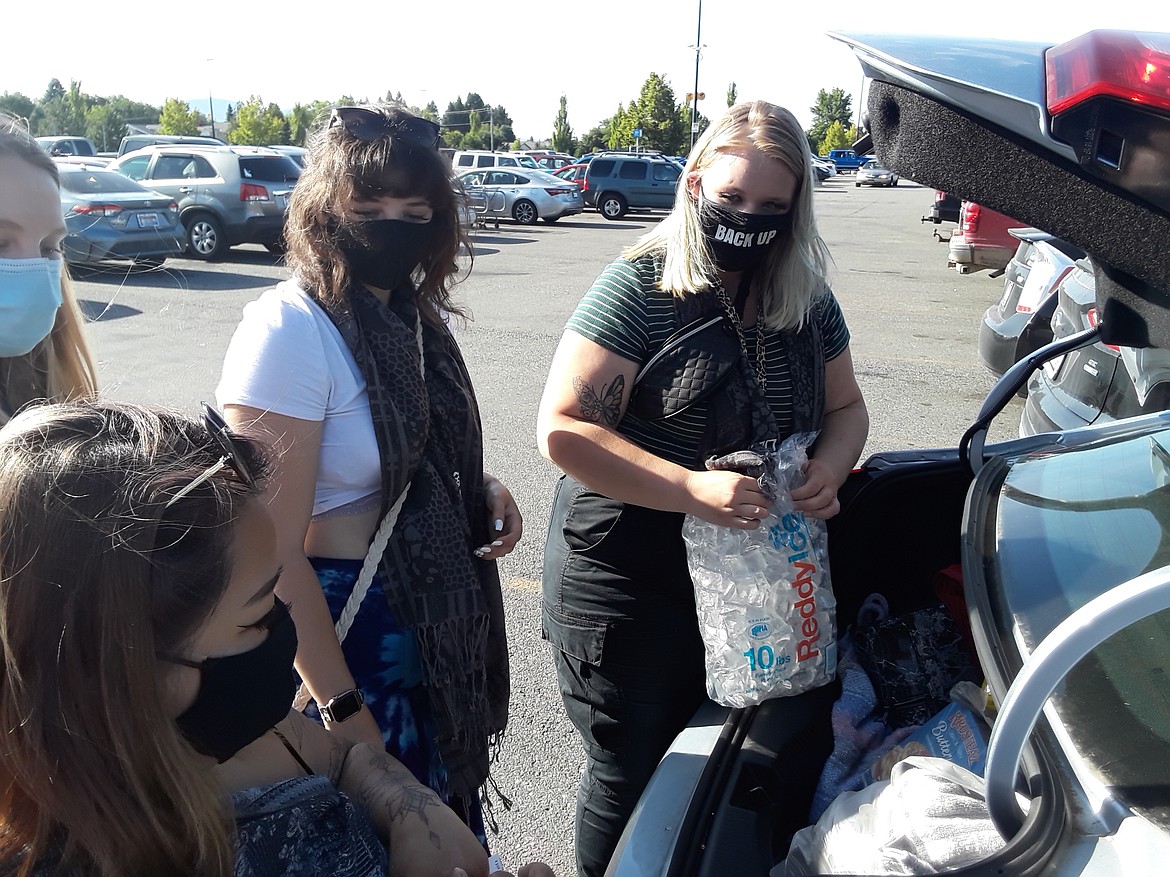 Emily Buchta, right, loads her car after leading her friends on a grocery run to the Hayden Walmart Wednesday afternoon. Starting Monday, the retailer will require all its customers to wear masks in its stores nationwide.