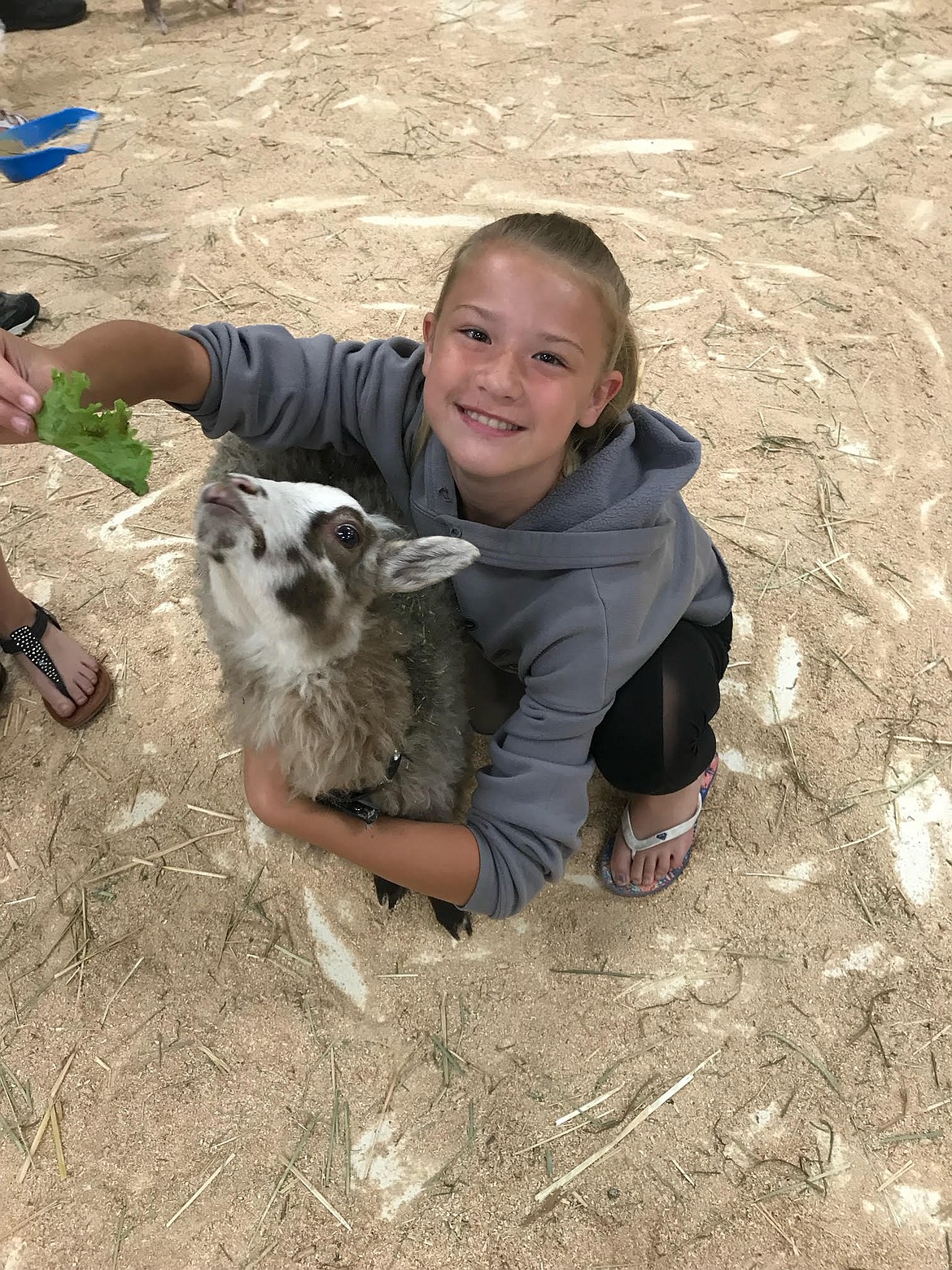 Tammi Hite, 12, makes friends with a hungry goat in Big Red's Barn in July 2019. The incoming Woodland Middle School seventh-grader underwent brain surgery May 1 followed by several medical emergencies and will need another operation this summer, but she's keeping a smile on her face through it all. (Courtesy photo)