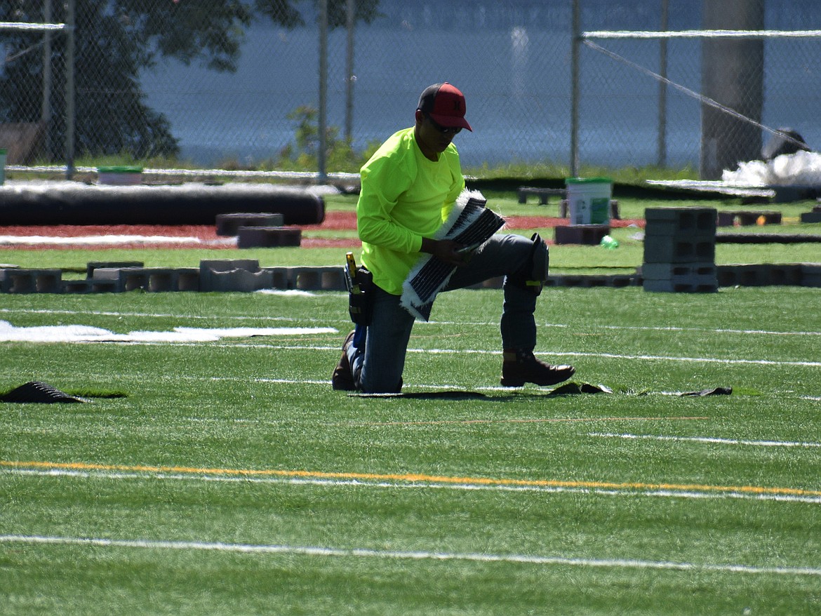 (Photo by DYLAN GREENE) A worker picks up hash marks at War Memorial Field on Wednesday.