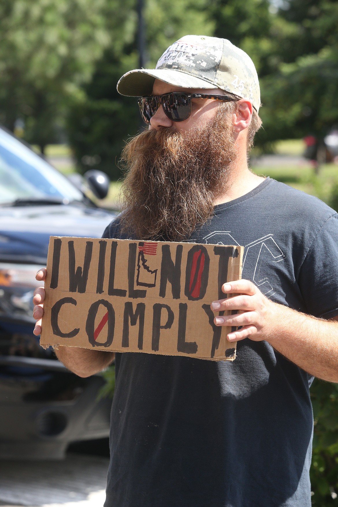 BILL BULEY/Press 
 Jake Kopp holds a sign outside the meeting of the Panhandle Health District board on Friday.