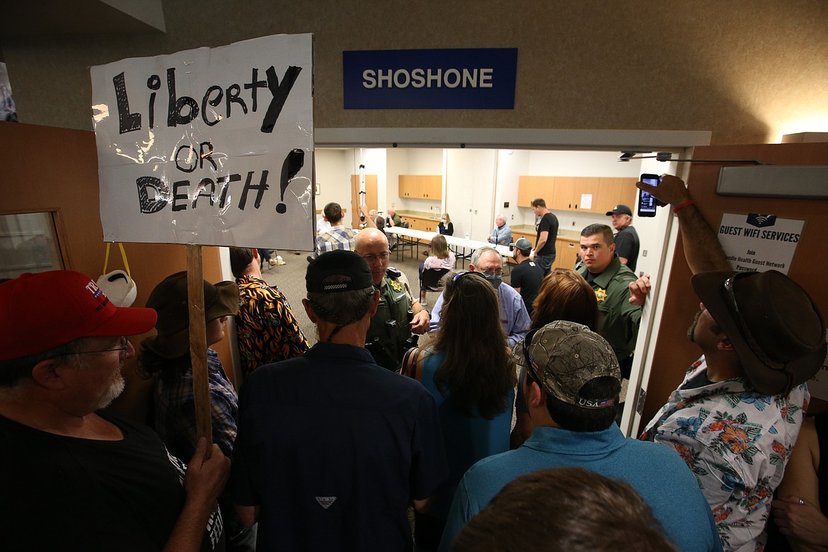 BILL BULEY/Press 
 A crowd gathers at the doorway of the Panhandle Health District board meeting on Friday, while Kootenai County deputies are on duty.