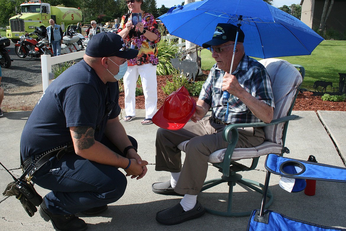 Geb Galle (right) talks with Scott Anderson of Grant County Fire District No. 5 Sunday. Galle, a World War II veteran, was honored with a parade of fire trucks and law enforcement vehicles, escorted by the Patriot Riders motorcycle group, to celebrate Galle’s 99th birthday.