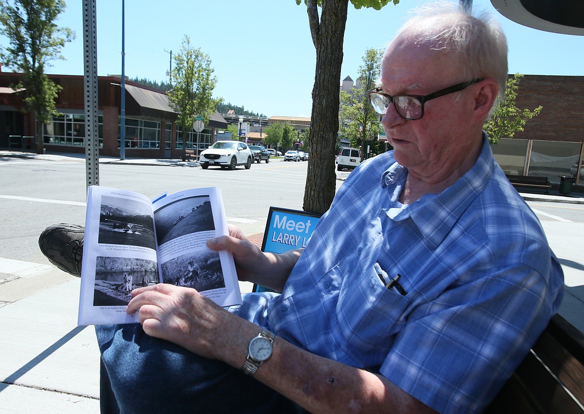 Larry Whitesitt points to some old photos in his newest book, “A Father and Son’s Yukon Bush Pilot Adventures,” during a visit to downtown Coeur d’Alene last week. He will sign books at the Paperhouse in St. Maries on Saturday.