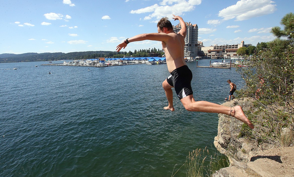 Jared Stephens takes a running leap into Lake Coeur d’Alene from the rocks at Tubbs Hill. (BILL BULEY/Press)