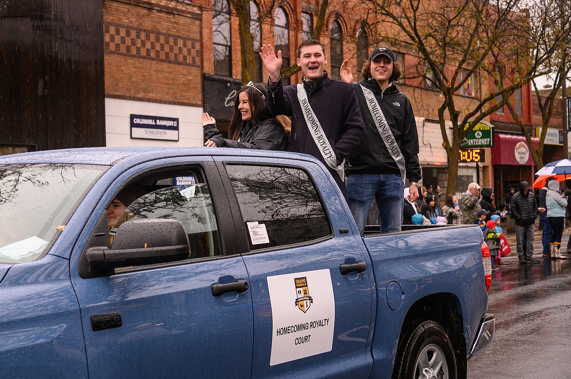 Homecoming royalty ride along Main Street in Moscow during the 2019 University of Idaho Homecoming Parade. U of I 2020 grad James Trayford waves from the center, joined by Katherine Nolan on the left and Luke Tesnohlidek. (Photo courtesy of University of Idaho Photo Services)