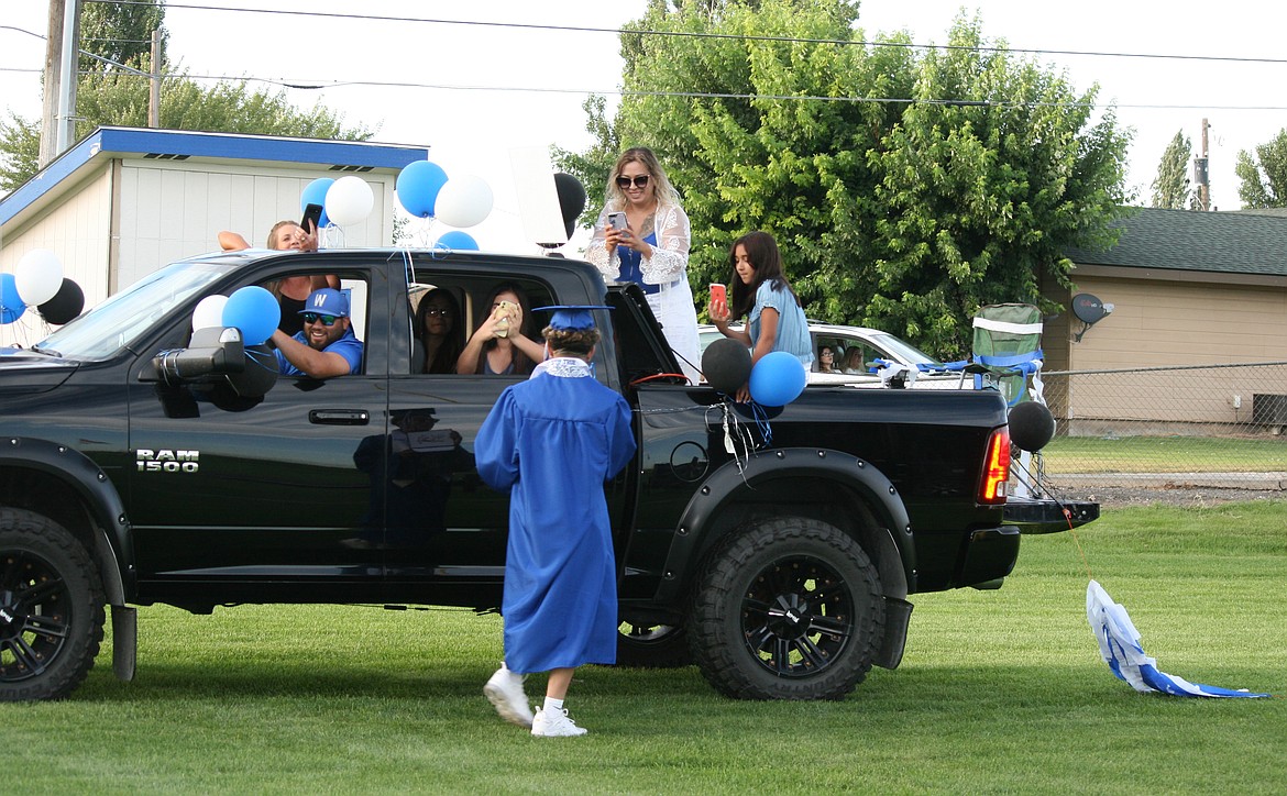 Cheryl Schweizer/Columbia Basin Herald 
  
 Proud family members snap photos of a brand-new Warden High School graduate and his diploma during ceremonies Friday.