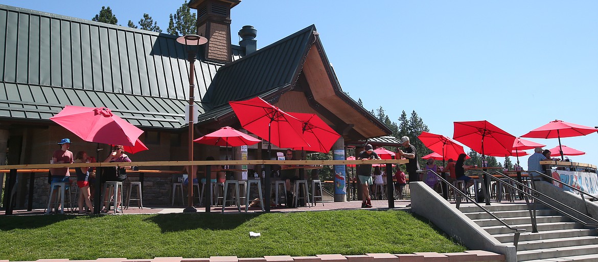 Patrons seek cover beneath red umbrellas Monday at the Buoy CDA by Tubbs Hill. North Idaho will experience a heat wave this week with temperatures possibly reaching or exceeding 100 degrees on Thursday. (DEVIN WEEKS/Press)