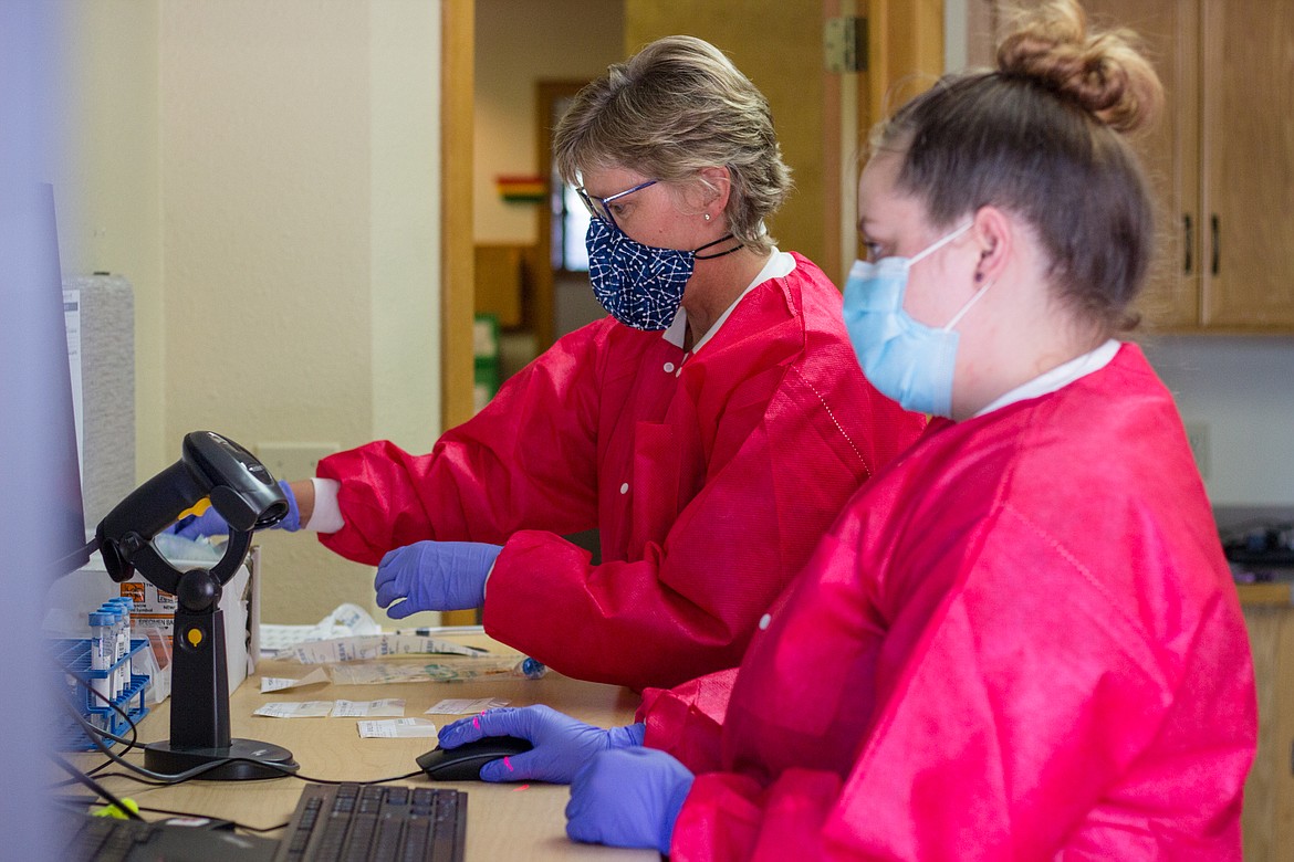 Chris Breazeal, medical lab scientist, and Melanie Goldsmith, lab assistant, examine a specimen during a COVID-19 test. The Kootenai Health employees have been among the hospital staff at the front lines of the pandemic who have witnessed a sharp rise in the percentage of hospitalizations in the past three weeks. (Courtesy of Kootenai Health)