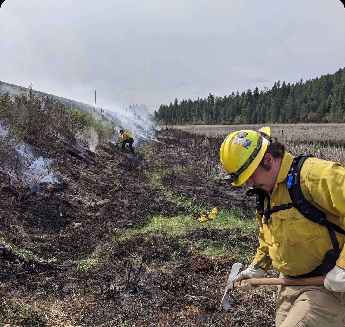 Timberlake Fire Protection District Firefighter Jack Duclos, right, works to put out a fire off Kelso Lake Road on May 12. The fire was started by children playing with matches.
As fire season heats up in North Idaho, officials ask that people remain cautious and vigilant. A majority of recent fires have been caused by humans. (Photo courtesy of Timberlake Fire)