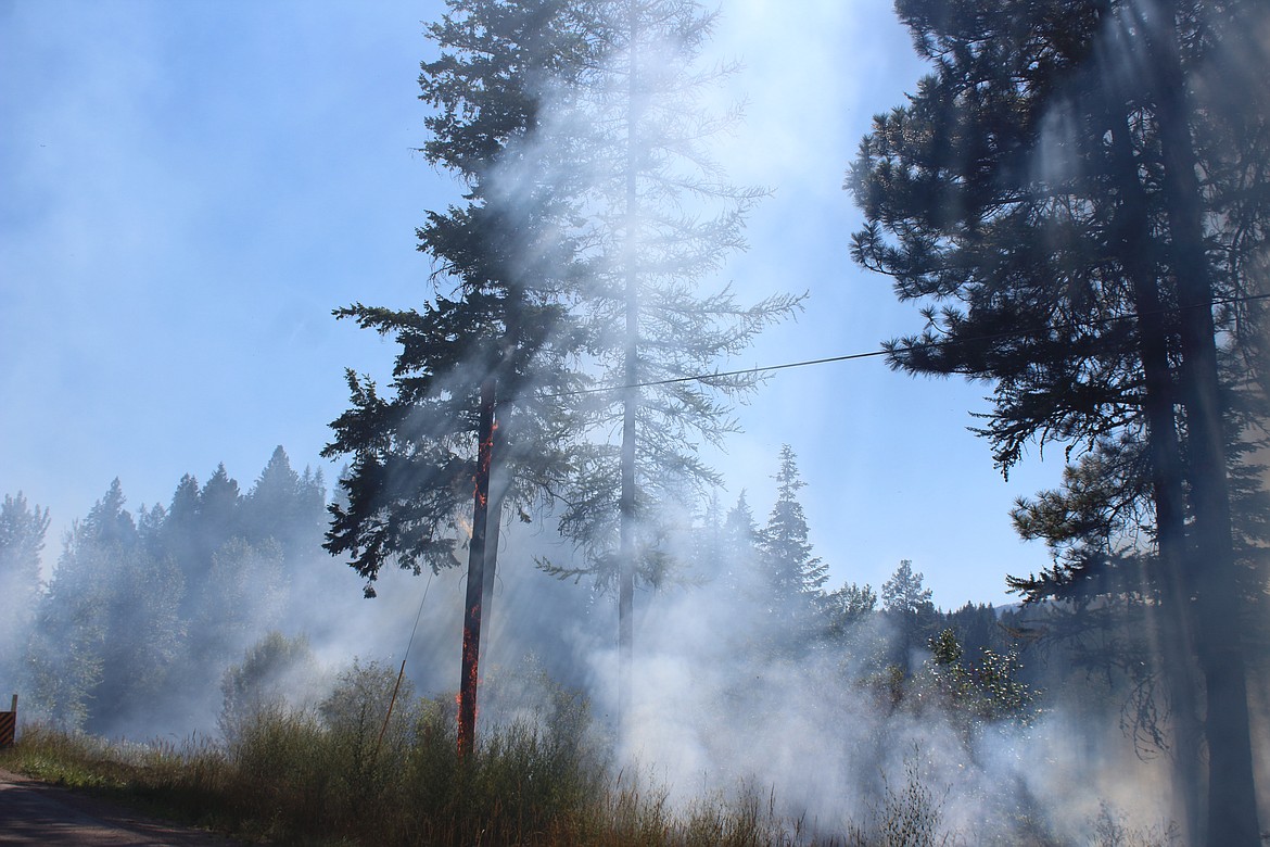 (Photo by VICTOR CORRAL MARTINEZ) 
 Wildfires spread along southbound lane in the the 499000 block of U.S. 95 on Monday afternoon.