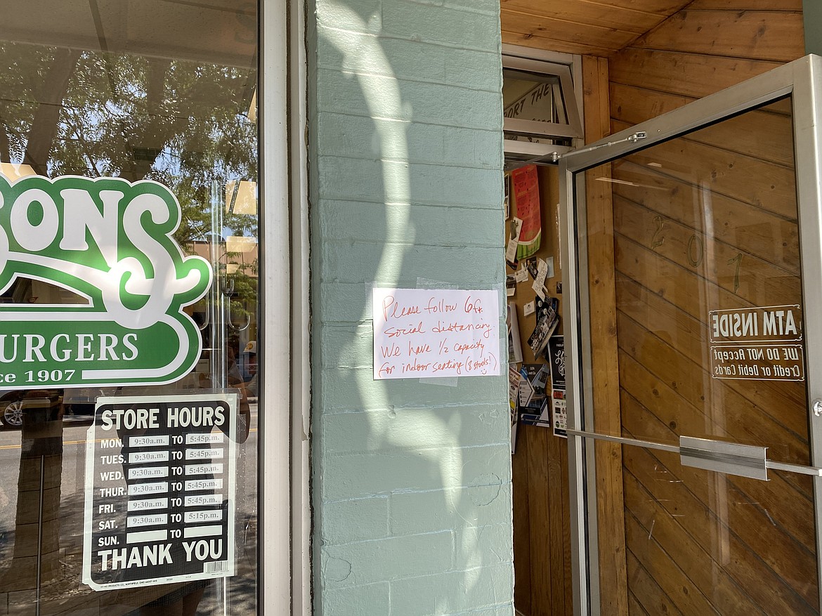 Hudsons Hamburgers encourages patrons to keep their distance while waiting to order with a sign outside the door. (MADISON HARDY/Press)