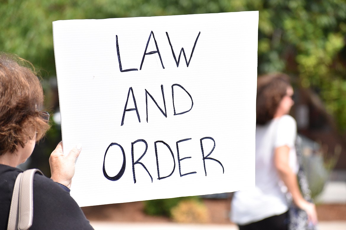 (Photo by DYLAN GREENE)
A woman holds up a “Law and Order” sign at Saturday’s event.
