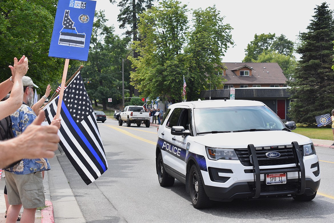 (Photo by DYLAN GREENE)
Residents cheer as a Sandpoint Police vehicle drives by during Saturday’s event.