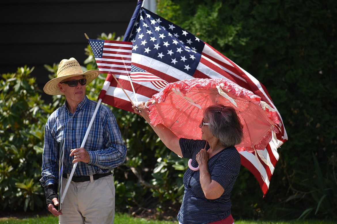 (Photo by DYLAN GREENE)
A woman tries to stay cool while waving an American flag at Saturday’s rally.