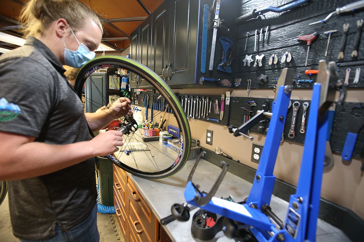 Jacob Reynolds works on a bike wheel at Mountain View Cyclery. (BILL BULEY/Press)