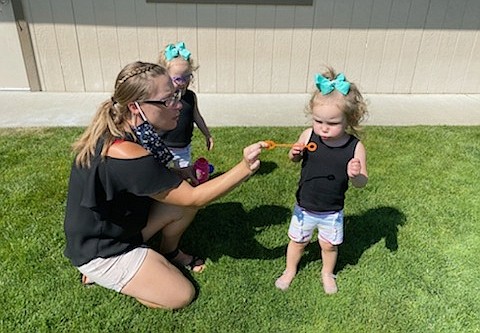 ABCD Daycare employee Heidi Liden blows bubbles with Aria and Adalyn Emerson on Tuesday at the Hayden site. Child care in Idaho and across the nation is struggling as it continues to manage the COVID-19 pandemic and prepare for when school resumes this fall. "I've owned ABCD for 30 years, and this is probably one of the toughest years I've ever had," owner Chris Bjurstrom said. (Courtesy photo)