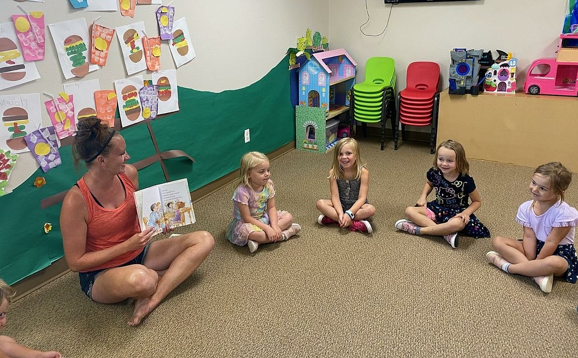 Ashley Lenz, left, reads about bubbles with Addilee Schooley, Maddie Gunderson, Casey Campbell and Lillyanna Haug at ABCD Daycare in Hayden on Tuesday. Child care in Idaho is in crisis right now as costs have increased, enrollment has decreased and uncertainties lie ahead while school reopening looms on the horizon. (Courtesy photo)