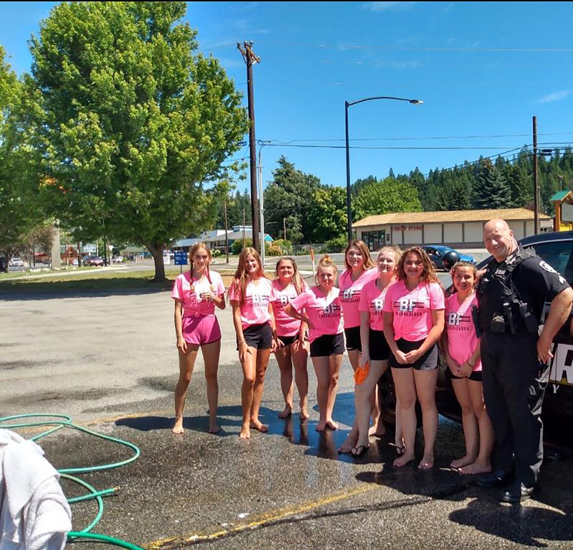 (Courtesy photo) 
 Bonners Ferry High School cheerleaders welcome a local law enforcement officer to their recent car wash. Pictured are Ember Allred, Bellla Sims, Kynsie Hinrichs, Addy Heigel, Kylie Underhill, Kylie Callahan, Hailey Kelsey, Gena Kelsey and school resource officer Dales Anderson.