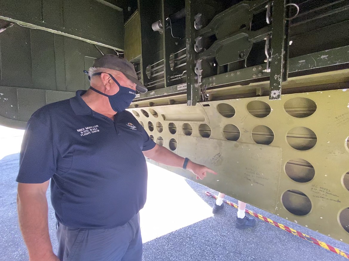 Ground operator and ride coordinator Mike Mueller points to the signature of World War II veteran signatures inside of the Maid in the Shade's bomb bay. (MADISON HARDY/Press)