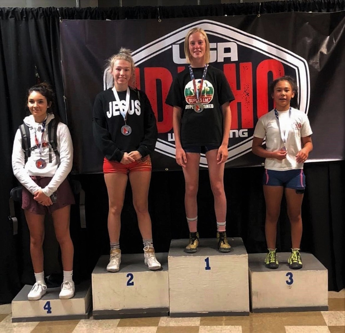 Sandpoint’s Kayelin Johansen (second to left) stands atop the podium to receive her second place freestyle medal at 112 pounds in the girls 16U/Junior category at the USA Wrestling Idaho State Championships on July 24-25 in Twin Falls.