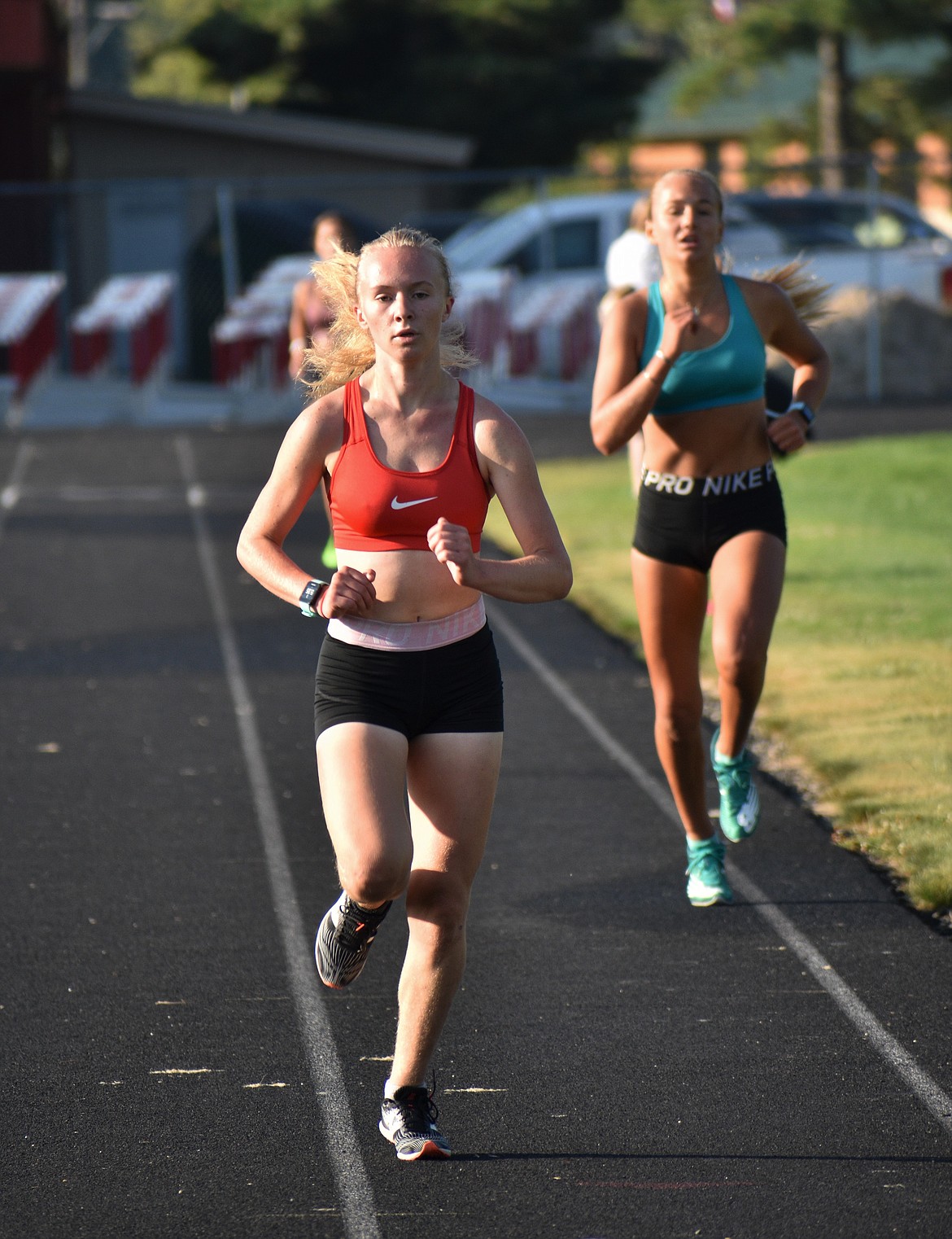 Mackenzie Suhy-Gregoire (left) leads Ara Clark as the girls near the finish line of the mile trial on Tuesday.