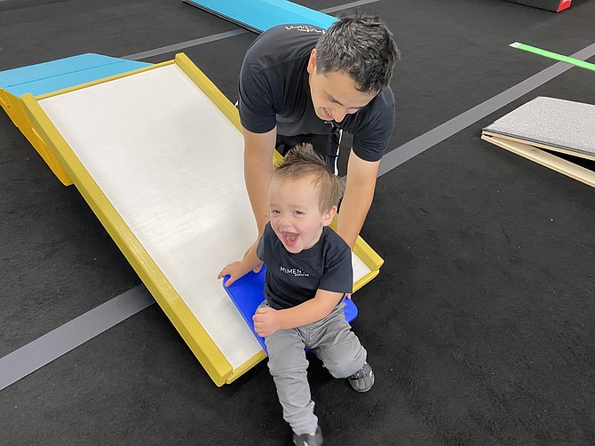 Josh Terra and son Finn test out the ramp slide at Momentum Sports and Play’s new center in Coeur d’Alene.