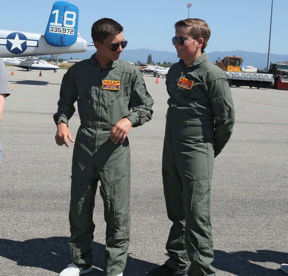 Ethan Hickok and Jackson Payne share an exchange Friday at the Coeur d’Alene Airport as they imagine being in a WWII bomber flying at crazy angles while they’re briefed before their flight. They were two of seven Lake City Academy students who went for a ride in the “Made in the Shade” B-25J Mitchell. (DEVIN WEEKS/Press)