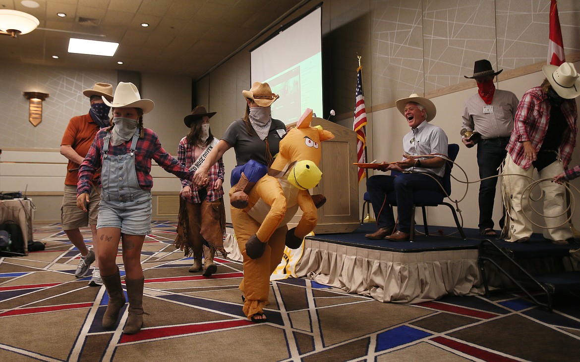 The "Rosy Bottom Bandits" bound away after highjacking Coeur d'Alene Rotary President Luke Russel's bell and gavel and tying him to a chair during the club's meeting Friday. Roses are available for purchaase now through the end of August and will be delivered Oct. 2. (DEVIN WEEKS/Press)