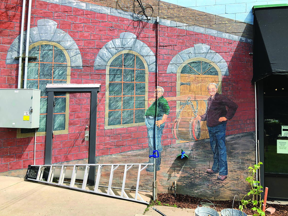 (Photo by Douglas Jones) 
 Douglas Jones takes after-shot of mural restoration on 220 Cedar Street. These two brewers are part of a larger mural display to memorial the history of manufacturing beer.