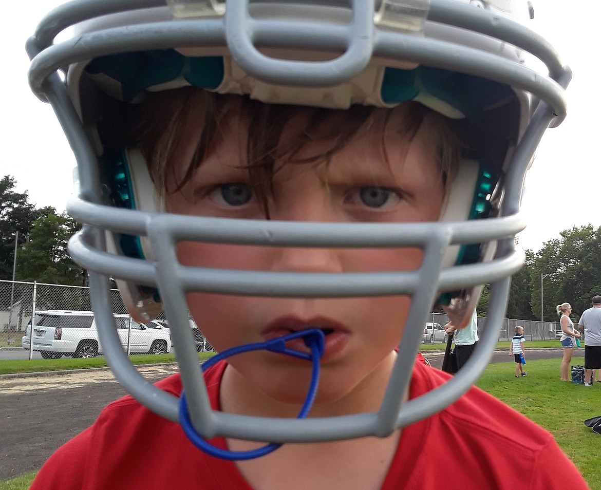 Eight-year-old Austin Little demonstrates his game face Monday after football practice. Little is one of approximately 400 kids to sign up for Coeur d'Alene Jr. Football this fall amid the COVID-19 pandemic. "With everything that’s happened this year," Caitlin Hazard, Austin's mother, told The Press, he needs football to have some normalcy." (CRAIG NORTHRUP/Press)