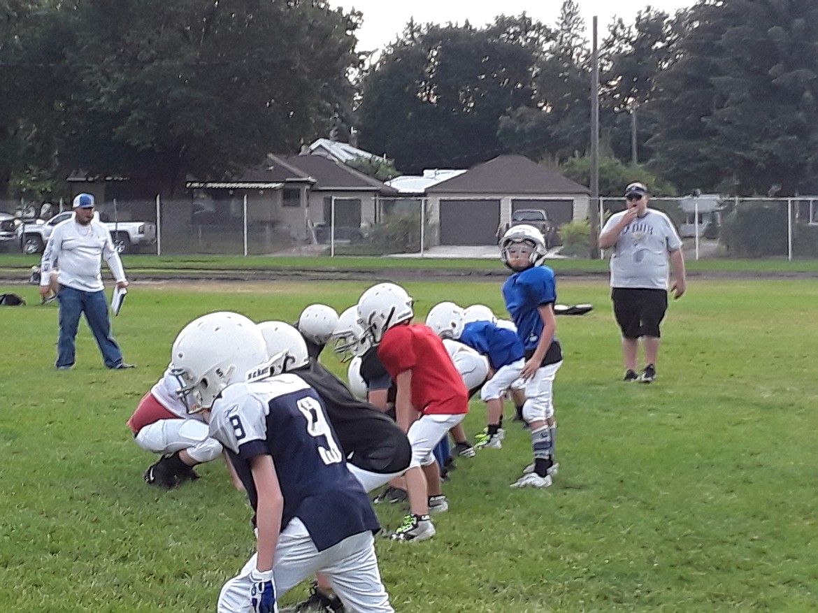 The Huskies offense lines up during a Monday practice. The CDC recommends coaches should wipe down footballs and other equipment before and after games as a result of the COVID-19 pandemic. (CRAIG NORTHRUP/Press)