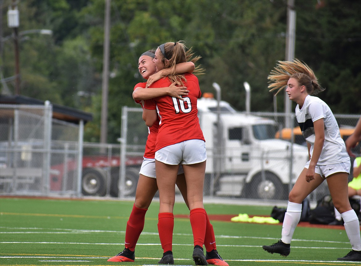 (Photo by DYLAN GREENE) 
 Kylie Williams (right) hugs Jordie Breeden after scoring the first goal during Friday's home game against Lake City.